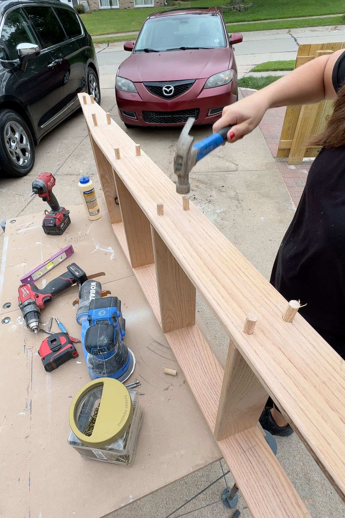 Adding dowels to cover screw holes on a ladder for DIY bunk beds.